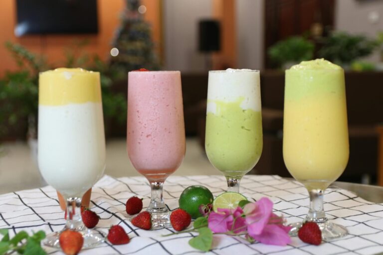 A vibrant array of healthy fruit smoothies in wine glasses, perfect for a balanced diet.